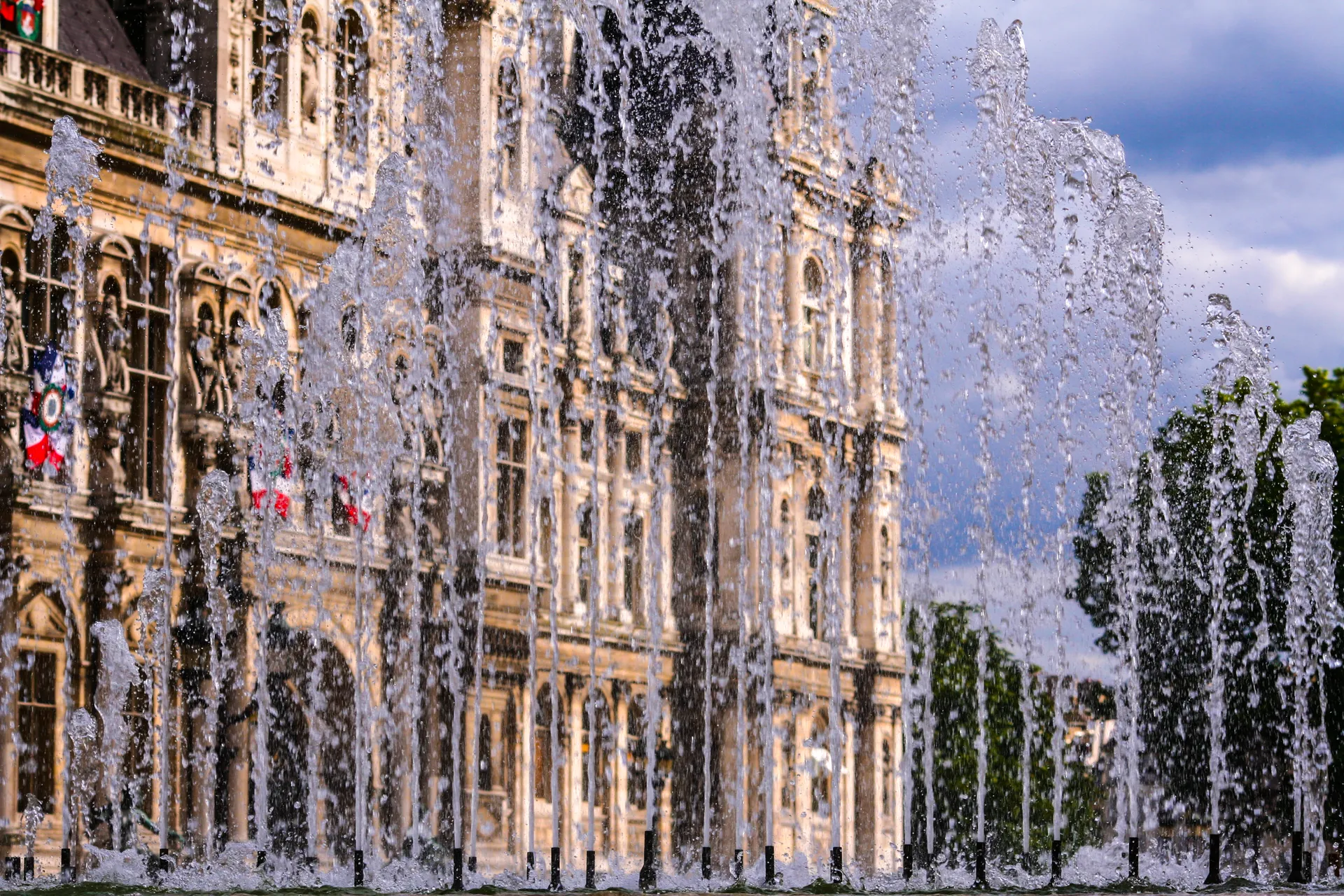 Jets d’eau d’une fontaine devant la façade d’un bâtiment public.
